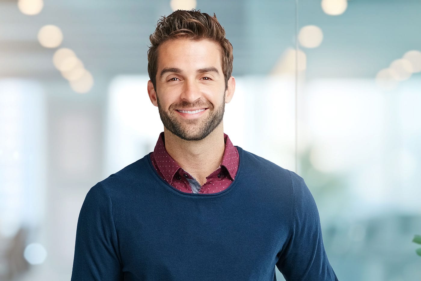 A man smiling after hairline lowering/forehead reduction in Miami.